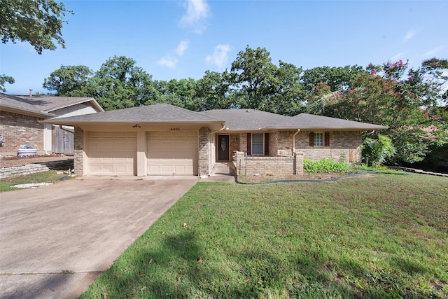 view of front of property featuring an attached garage, driveway, a front yard, and brick siding