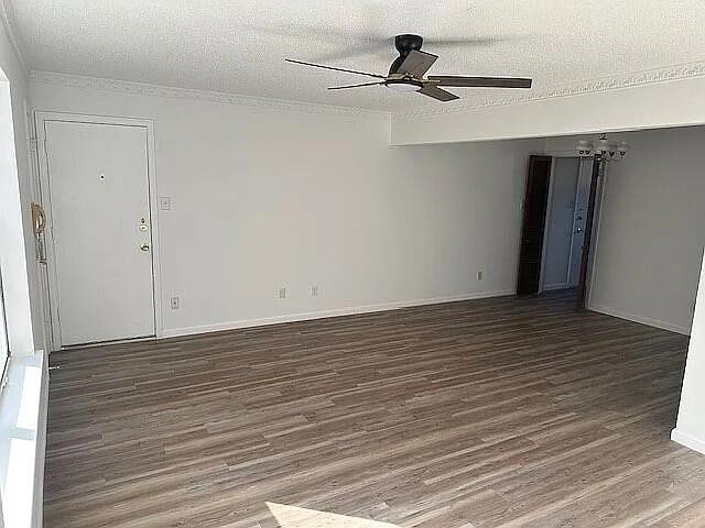 5817 Sandhurst Ln Unit B, Dallas, TX 75206 - empty room with a ceiling fan, wood finished floors, a textured ceiling, ornamental molding, and baseboards