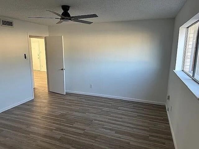 5817 Sandhurst Ln Unit B, Dallas, TX 75206 - empty room featuring dark wood-type flooring, ceiling fan, a textured ceiling, and baseboards