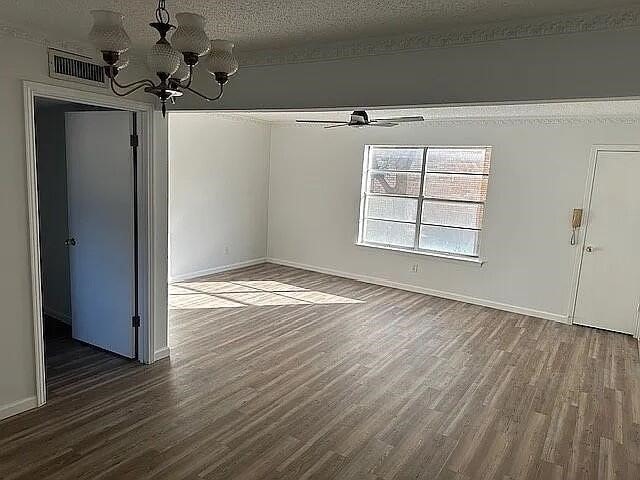 5817 Sandhurst Ln Unit B, Dallas, TX 75206 - unfurnished dining area with dark wood-style floors, a chandelier, baseboards, and a textured ceiling
