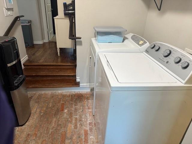 laundry area featuring washer and clothes dryer and brick patterned floors
