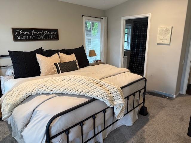 bedroom featuring carpet, baseboards, lofted ceiling, and connected bathroom