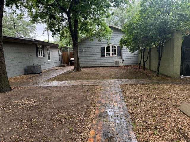 rear view of property featuring fence, central AC, and ac unit