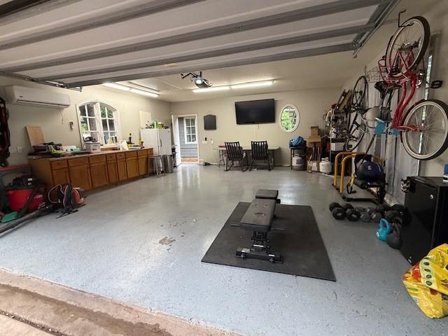 garage featuring a wall mounted air conditioner and a garage door opener