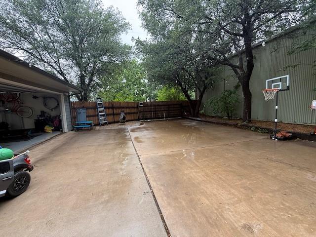 view of basketball court with fence and a gate
