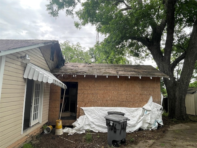 view of side of property with roof with shingles