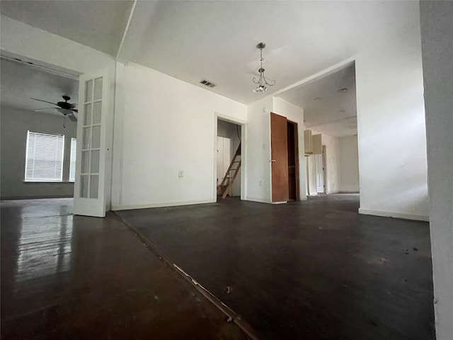 spare room featuring concrete floors, ceiling fan, stairway, and baseboards