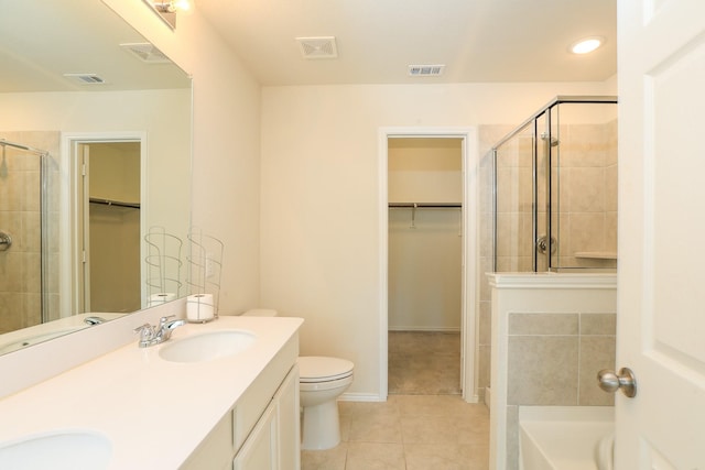 bathroom featuring tile patterned floors, a shower stall, a spacious closet, toilet, and recessed lighting