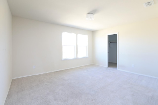 unfurnished bedroom with light colored carpet, baseboards, and a closet