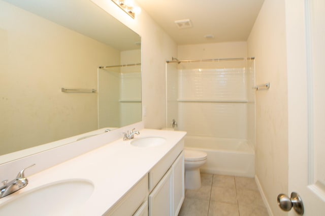 bathroom featuring tile patterned flooring, toilet, double vanity, shower / bath combination, and baseboards