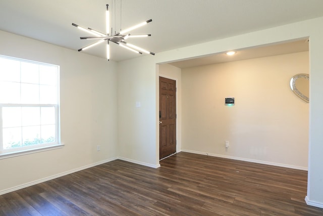 empty room with dark wood finished floors, baseboards, and plenty of natural light
