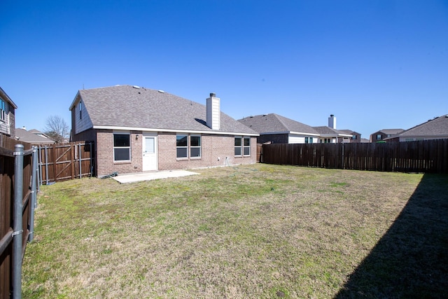 back of house featuring brick siding, a chimney, a patio, and a shingled roof