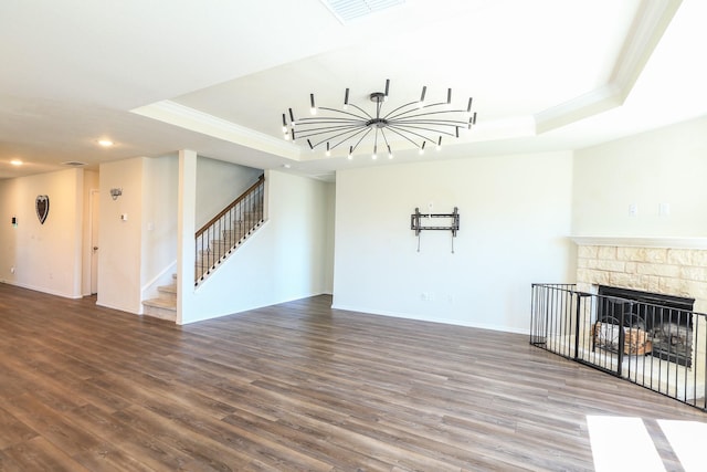 unfurnished living room with a tray ceiling, ornamental molding, recessed lighting, stairway, and wood finished floors