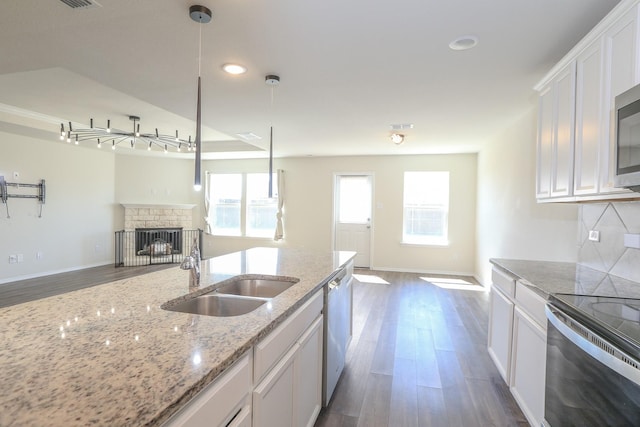 kitchen featuring a sink, open floor plan, stainless steel appliances, dark wood-style floors, and white cabinets