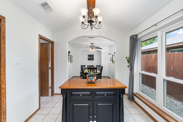 dining area featuring arched walkways, vaulted ceiling, light tile patterned floors, a chandelier, and ceiling fan