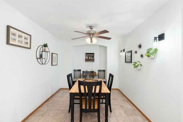 dining space featuring ceiling fan, baseboards, and light tile patterned floors