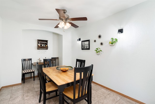dining area with a ceiling fan and baseboards