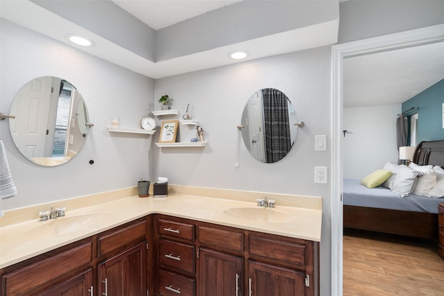 bathroom featuring double vanity, connected bathroom, recessed lighting, and wood finished floors