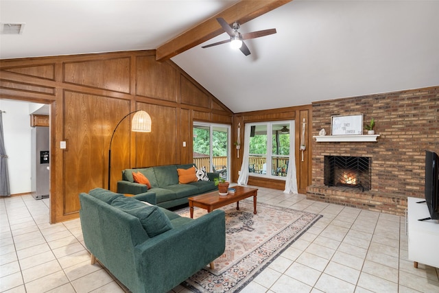 living room featuring light tile patterned floors, ceiling fan, a fireplace, and wood walls