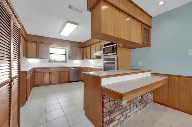 23010 County Road 3313, Chandler, TX 75758 - kitchen featuring stainless steel appliances, a sink, a peninsula, light countertops, and a textured ceiling