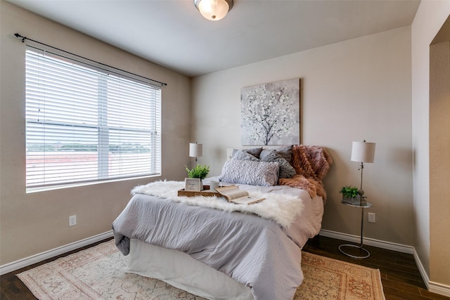 bedroom with dark wood finished floors and baseboards