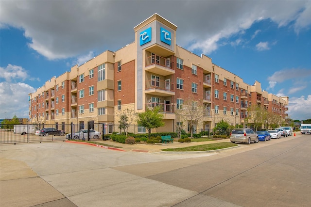 view of apartment building / complex featuring fence