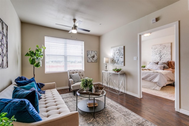 living area featuring a ceiling fan, wood finished floors, and baseboards