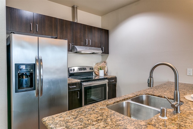 kitchen featuring appliances with stainless steel finishes, under cabinet range hood, a sink, and dark brown cabinetry