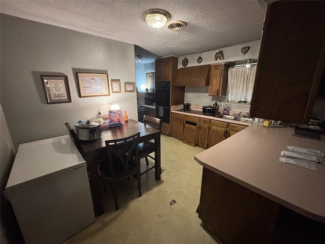 kitchen featuring a textured ceiling and refrigerator