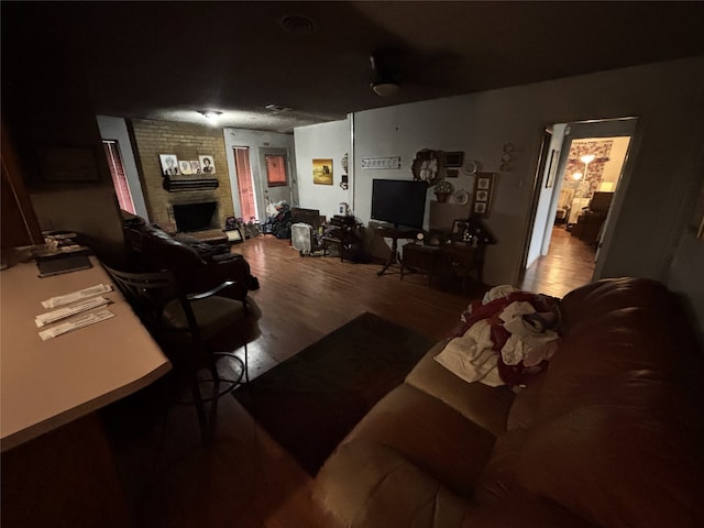 living room with a fireplace and wood finished floors