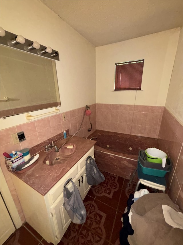 bathroom featuring tile walls, tile patterned flooring, a tub to relax in, a wainscoted wall, and vanity