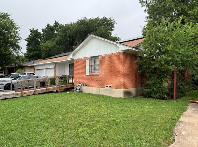 view of home's exterior featuring a yard, solar panels, and brick siding