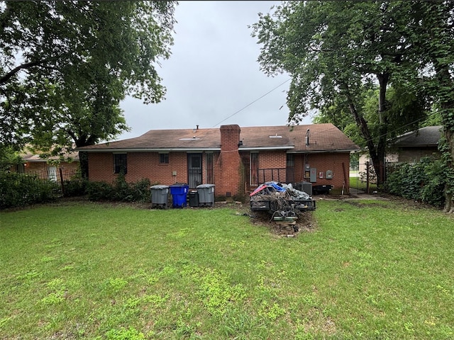 rear view of property with brick siding and a chimney