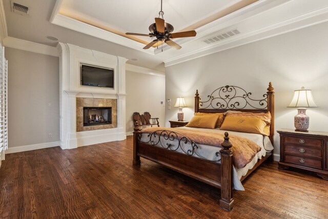 5957 Aberdeen Pl, Frisco, TX 75034 - bedroom with a tile fireplace, ornamental molding, wood finished floors, a raised ceiling, and baseboards
