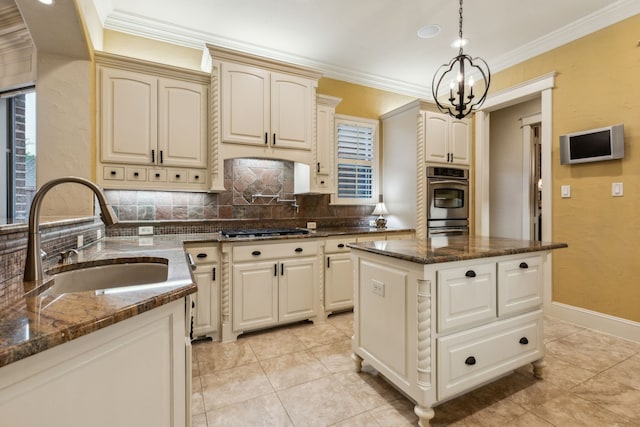 5957 Aberdeen Pl, Frisco, TX 75034 - kitchen with a sink, decorative backsplash, stainless steel gas stovetop, ornamental molding, and a center island