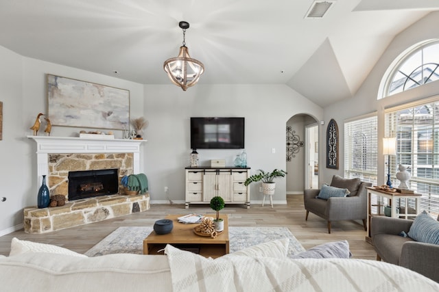 9529 Cholla Cactus Trl, Fort Worth, TX 76177 - living area featuring arched walkways, light wood-style flooring, vaulted ceiling, baseboards, and a fireplace
