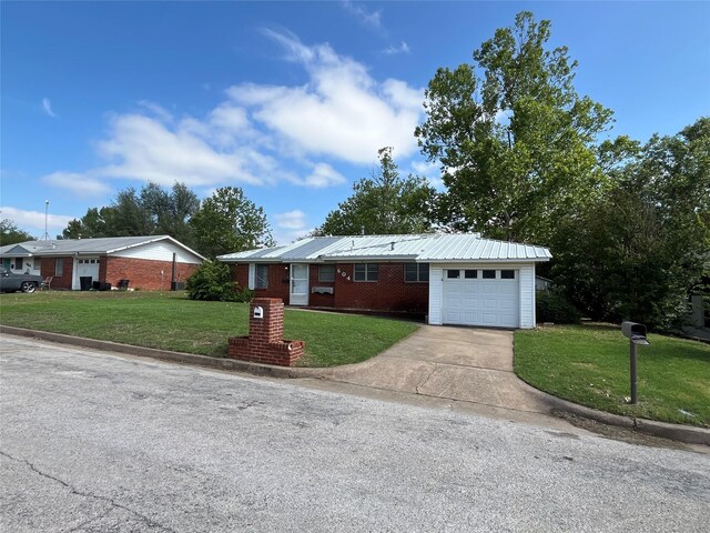 604 E 5th St, Weatherford, TX 76086 - ranch-style home with a front lawn, brick siding, driveway, a garage, and metal roof