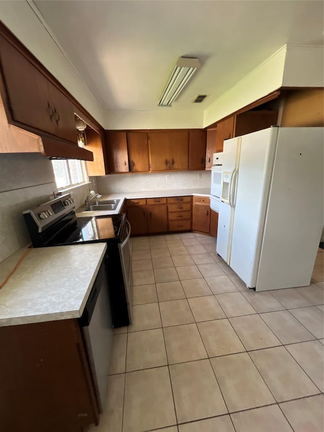 604 E 5th St, Weatherford, TX 76086 - kitchen featuring white appliances, a sink, light countertops, and light tile patterned flooring