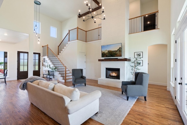 109 Old Decatur Rd, Decatur, TX 76234 - living area with a towering ceiling, wood finished floors, stairway, a warm lit fireplace, and baseboards