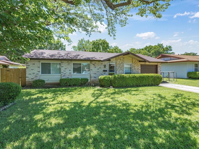 single story home with a garage, brick siding, driveway, and stone siding