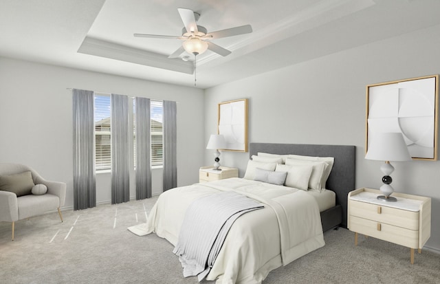 bedroom featuring carpet flooring, a tray ceiling, ceiling fan, and crown molding