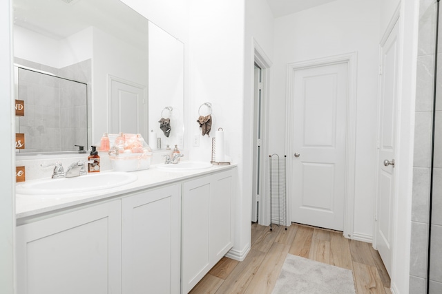 1034 Manuel Dr, Fate, TX 75087 - full bath featuring wood finished floors, double vanity, and tiled shower