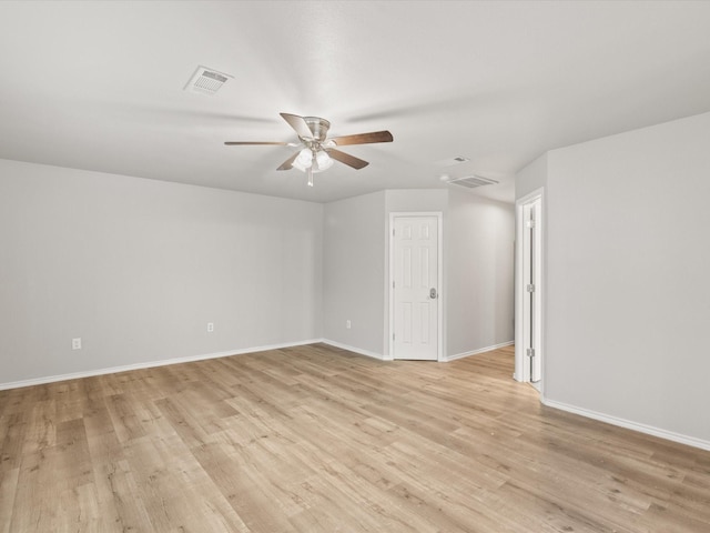 spare room featuring ceiling fan, light wood-type flooring, and baseboards