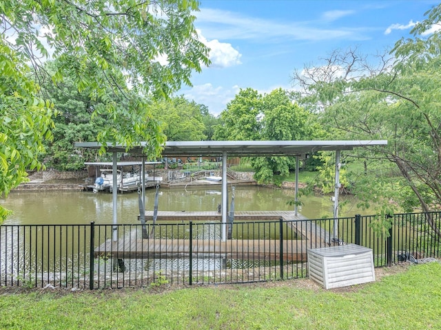 dock area with fence, a water view, and boat lift