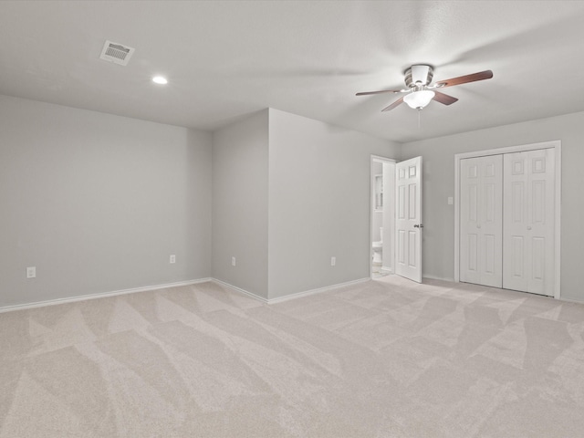 unfurnished bedroom with light carpet, baseboards, recessed lighting, ceiling fan, and ensuite bath