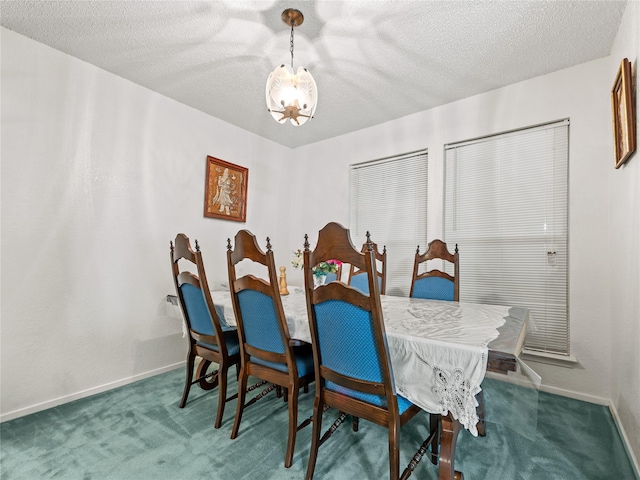 carpeted dining space featuring a chandelier, a textured ceiling, and baseboards