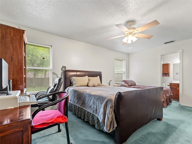 carpeted bedroom with a textured ceiling, a ceiling fan, connected bathroom, and an office area