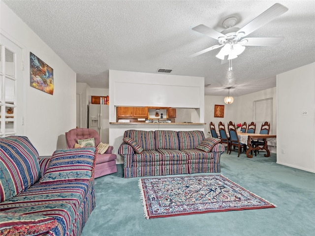 carpeted living room with a textured ceiling and ceiling fan