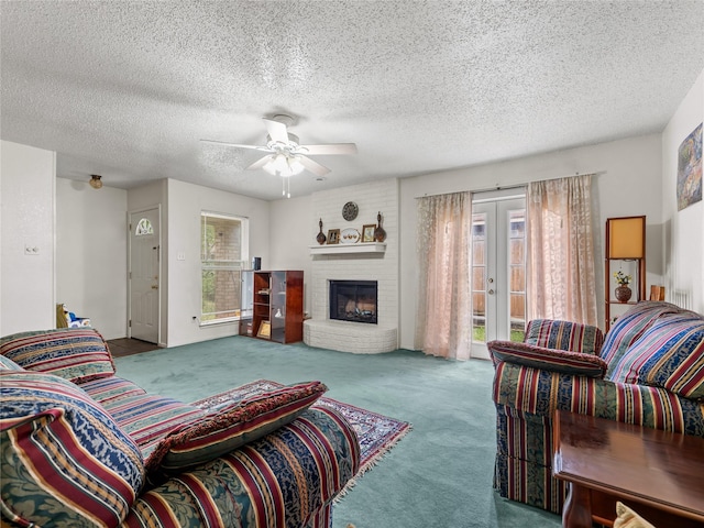 living room with carpet flooring, french doors, ceiling fan, a textured ceiling, and a fireplace