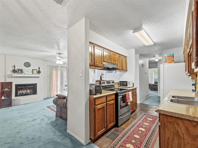 kitchen featuring stainless steel range with electric cooktop, white microwave, a textured ceiling, a sink, and ceiling fan